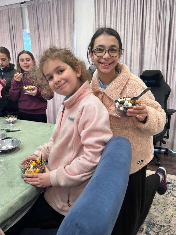 Two girls pose with their Acai bowls.