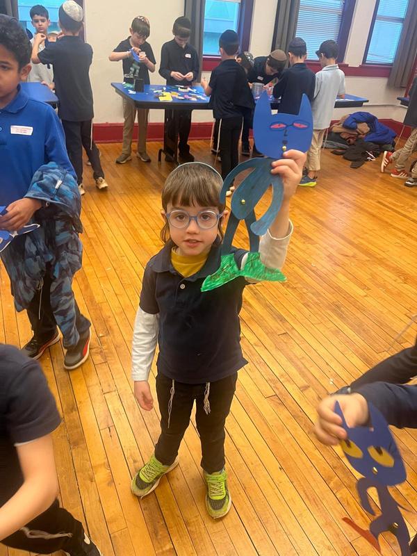 student showing is paper pete the cat puppet.