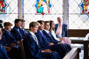 graduates smile in response to graduation remarks at graduation mass