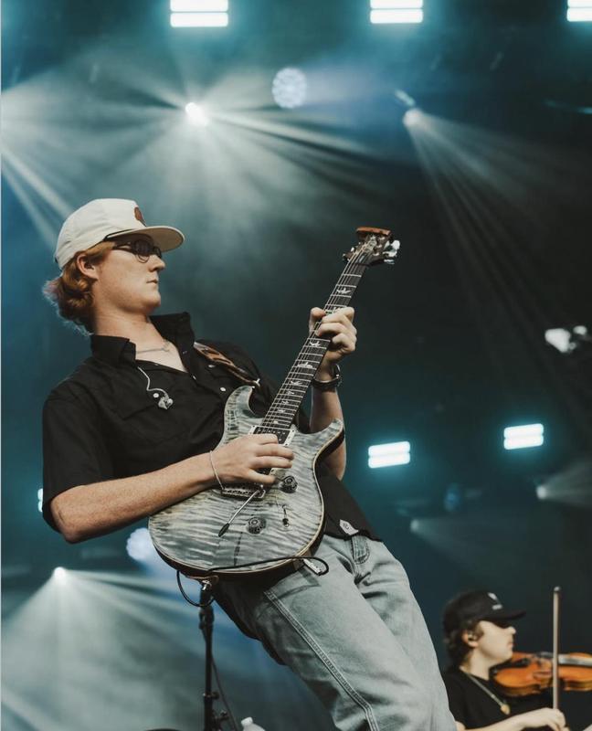 gage mcneely playing guitar during a show