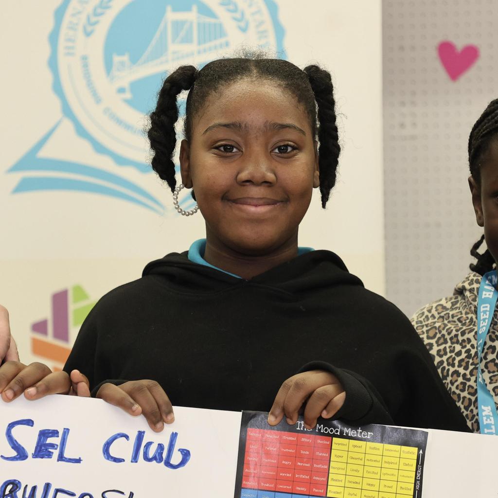 Student holding SEL club poster