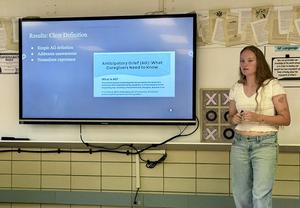 Presentation with a woman standing beside a screen displaying 'Conclusion'.