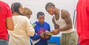 Keon Coleman signs autographs for a student