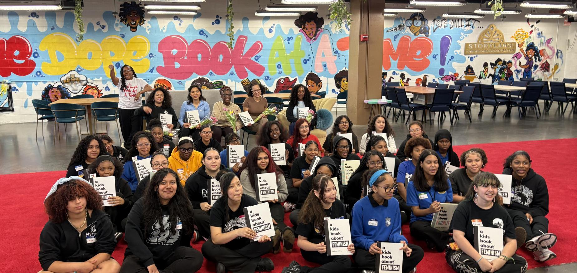group of students holding feminism book