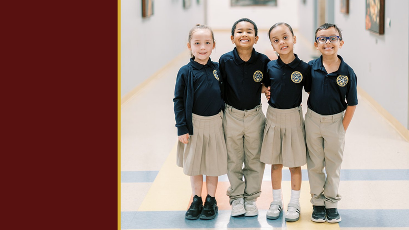Four smiling young students stand together in a school hallway