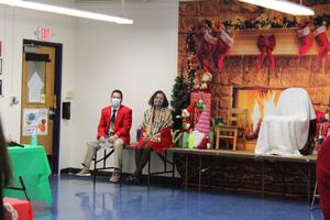 2 administrators sitting on table in front of fireplace backdrop