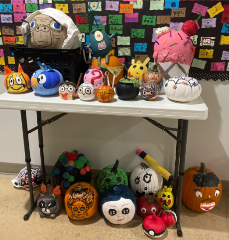 Pumpkins are painted and decorated to make items like E.T., Bluey, a pink ice cream cone, and characters from books and movies.