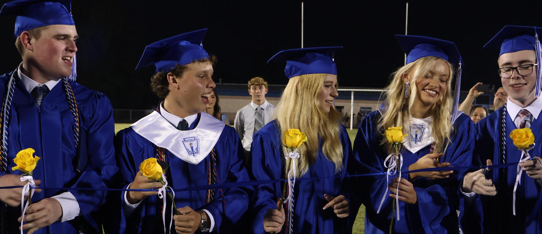 Graduated seniors cut ribbon for the Rose Ceremony