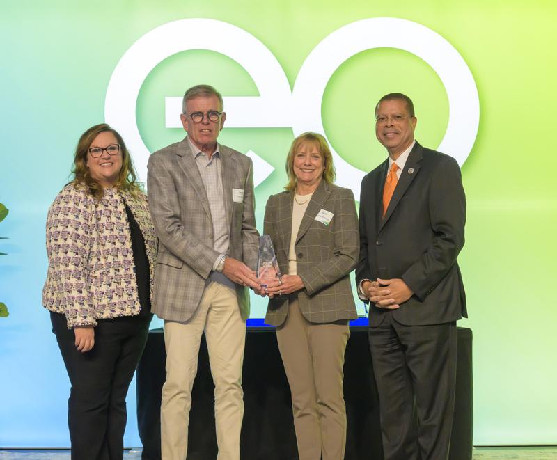 two community members receiving award on stage