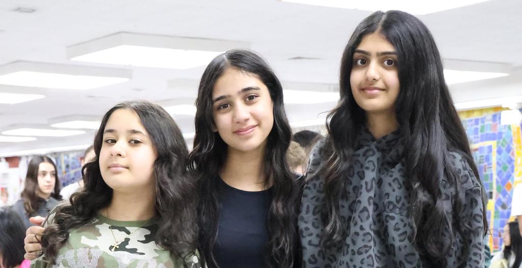 Two girls wearing camouflage shirts. One girl wearing camouflage pants.
