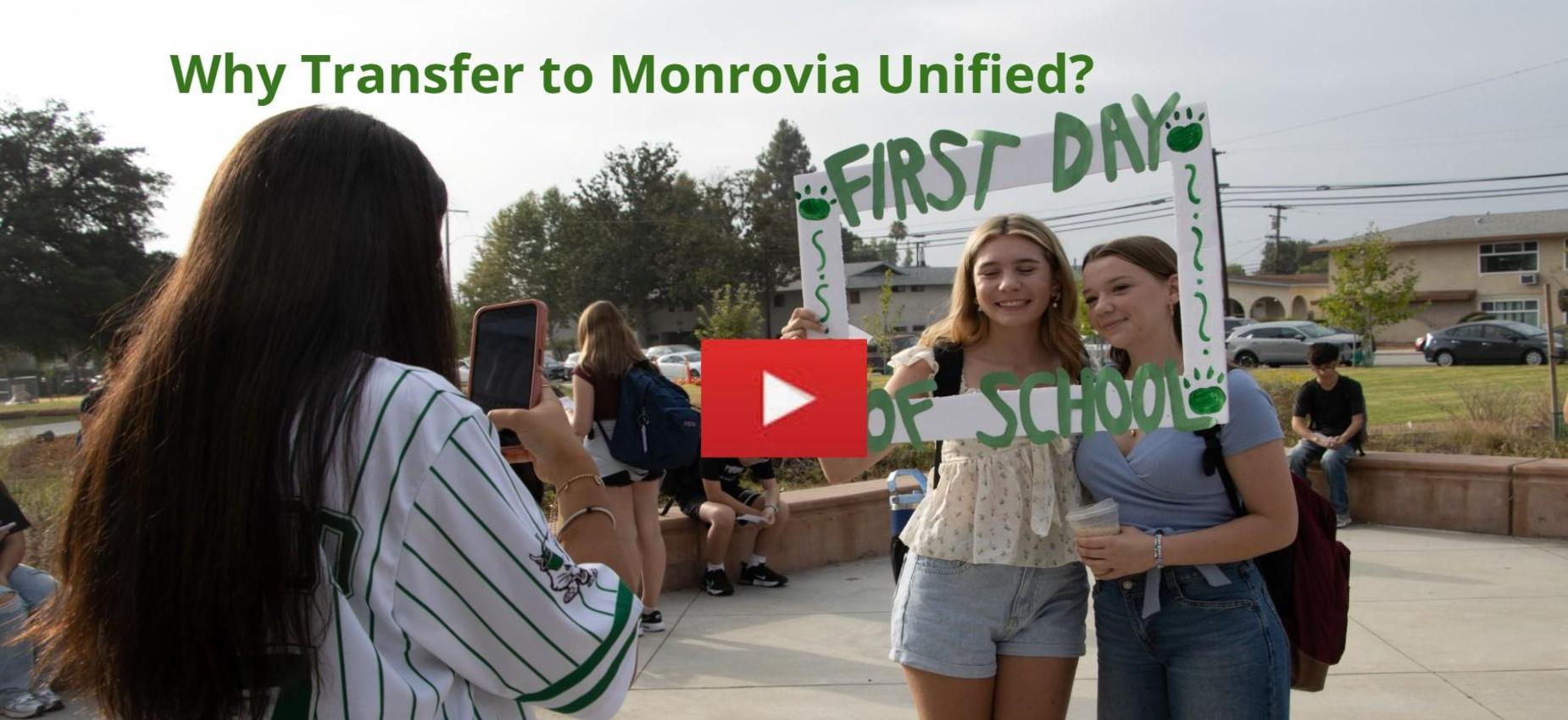 Two students pose for a photo holding a 'First Day of School' sign.