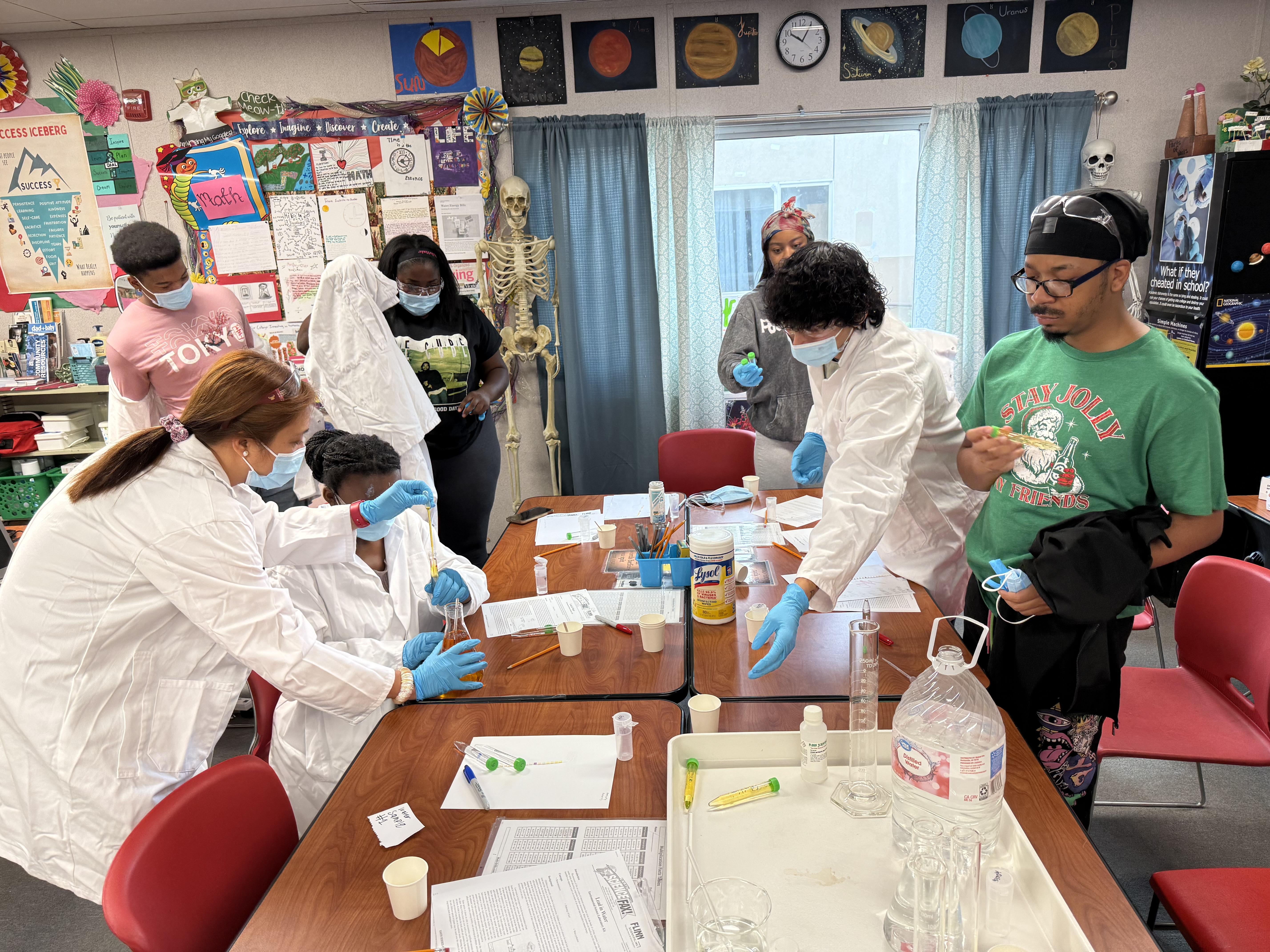 Teacher Ms. Gamit helps students with a science experiment