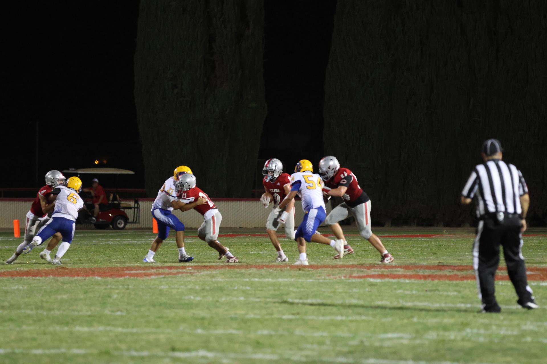 Varsity football players in action against Parlier 21