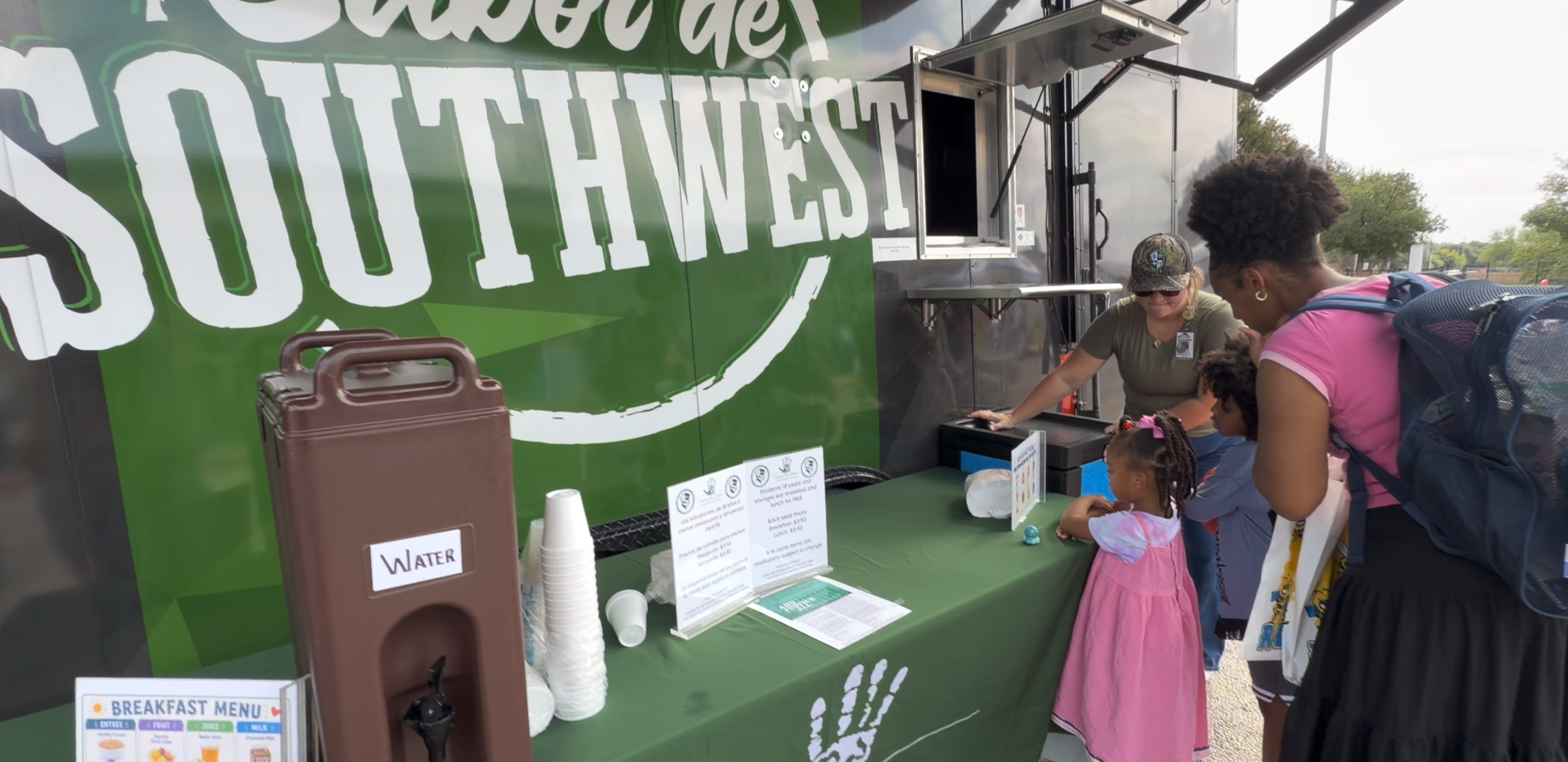 Group interacting at a food truck serving drinks and snacks.