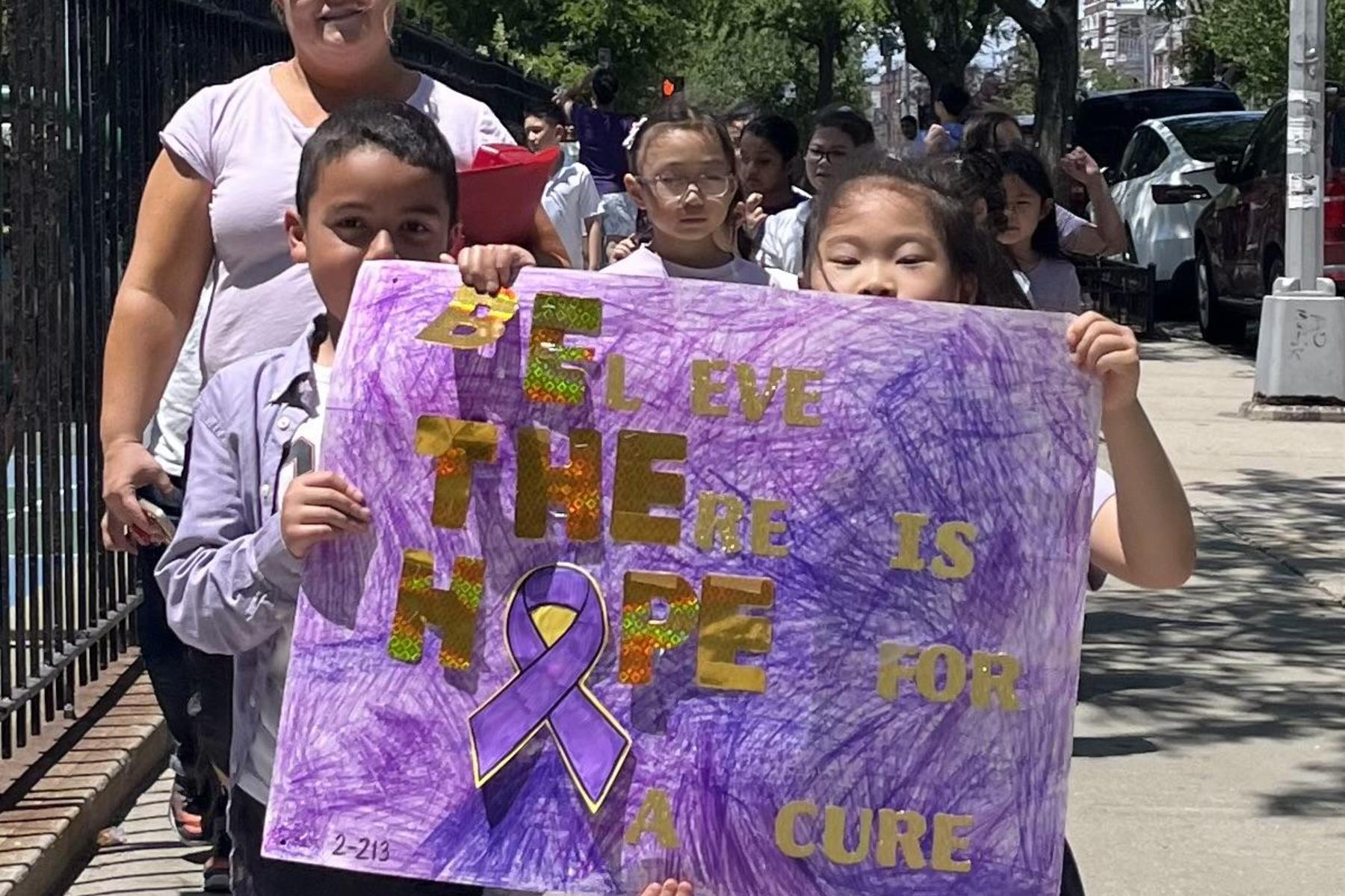 Children display a sign that emphasizes hope and a cure for Relay for Life.