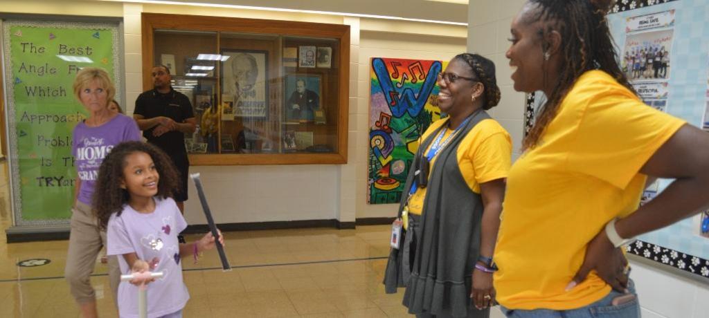 Girl talks with her principal and assistant principal.
