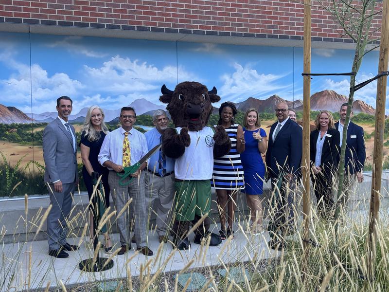 District and school leadership pose with Buffalo mascot at ribbon cutting ceremony.