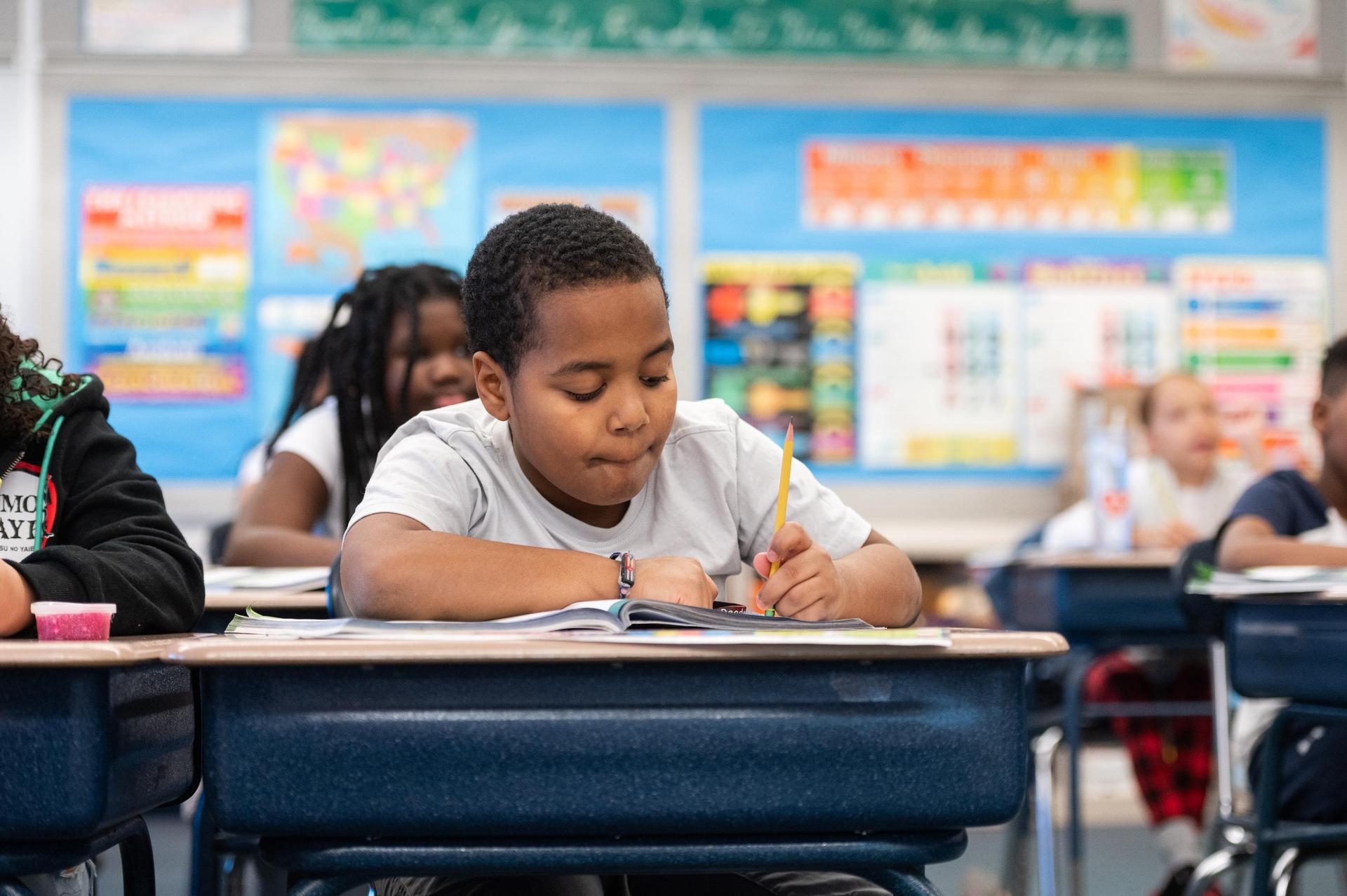 student writing at a desk
