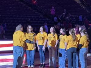 Student singing around the microphone on the court