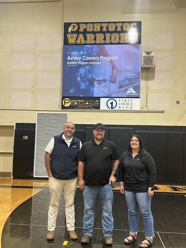 Picture of Ashley representatives standing in front of gym's video board