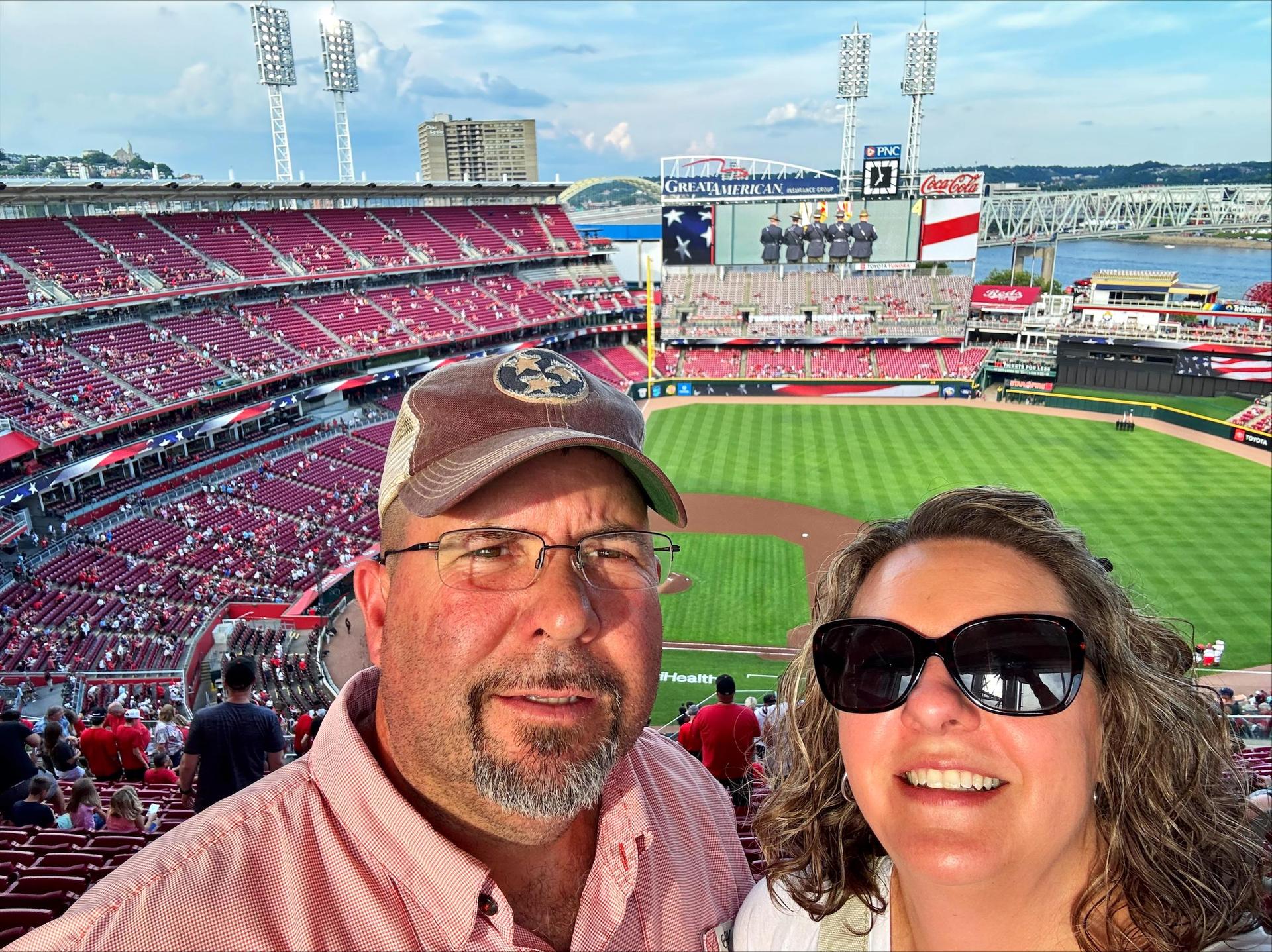 Man and women at baseball park. 
