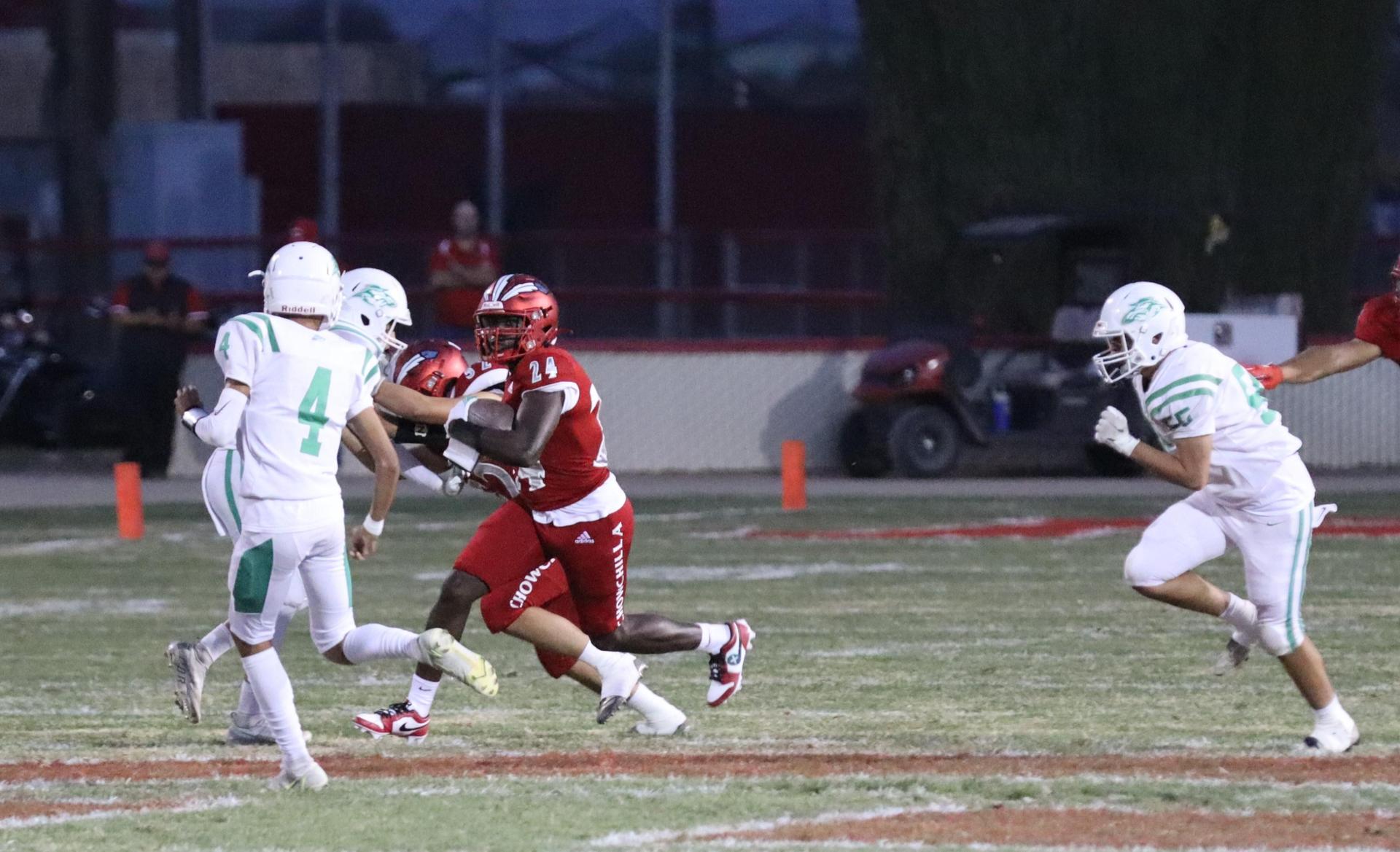 varsity football players in action against Riverdale