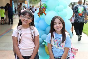 Two smiling girls standing in front of a balloon tower