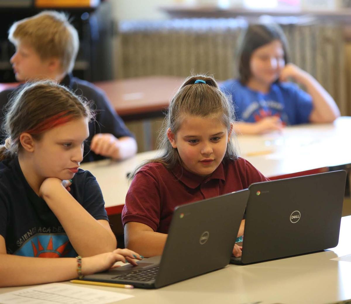 HSA Dayton Downtown student wearing headphones uses a laptop in class