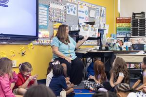 An elementary teacher reads to her first grade class