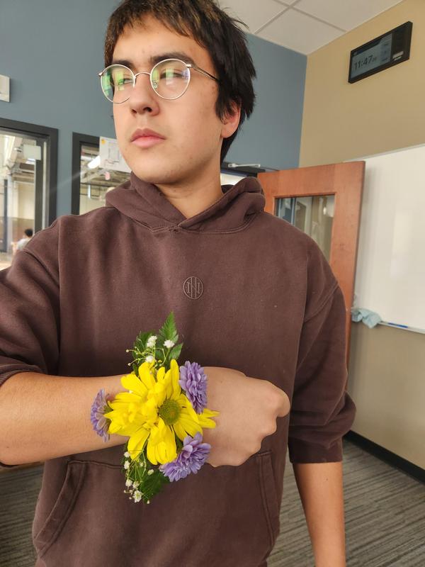 Adrian Lopez holding his hand showing off the corsage he made.