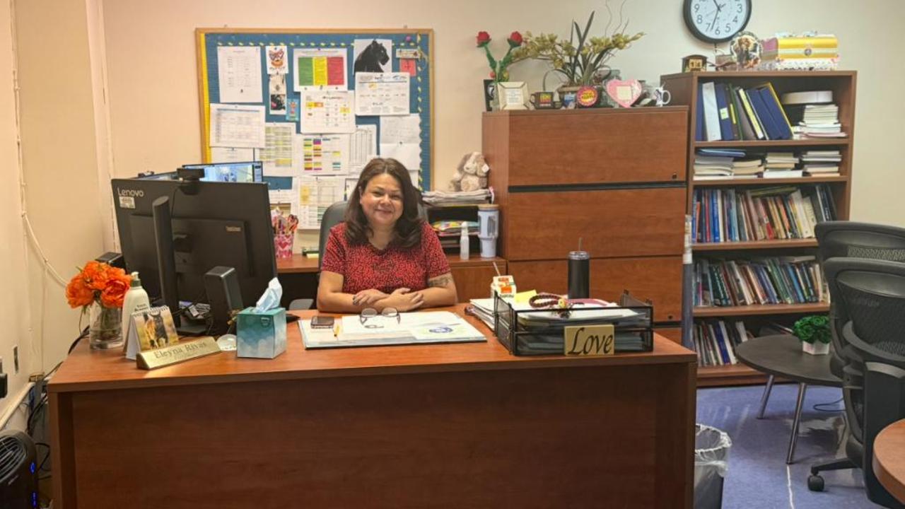 A woman sitting at a desk in a well-organized office space.