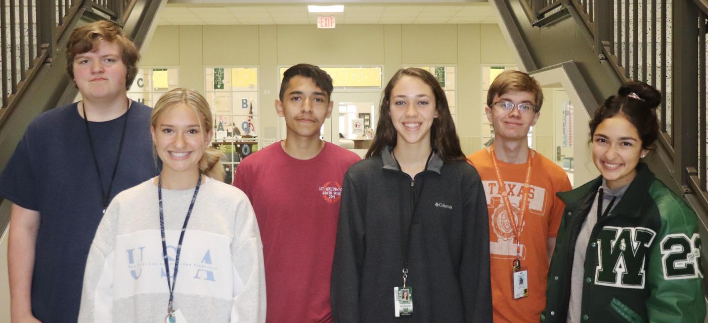 group of 6 students pose in front of library