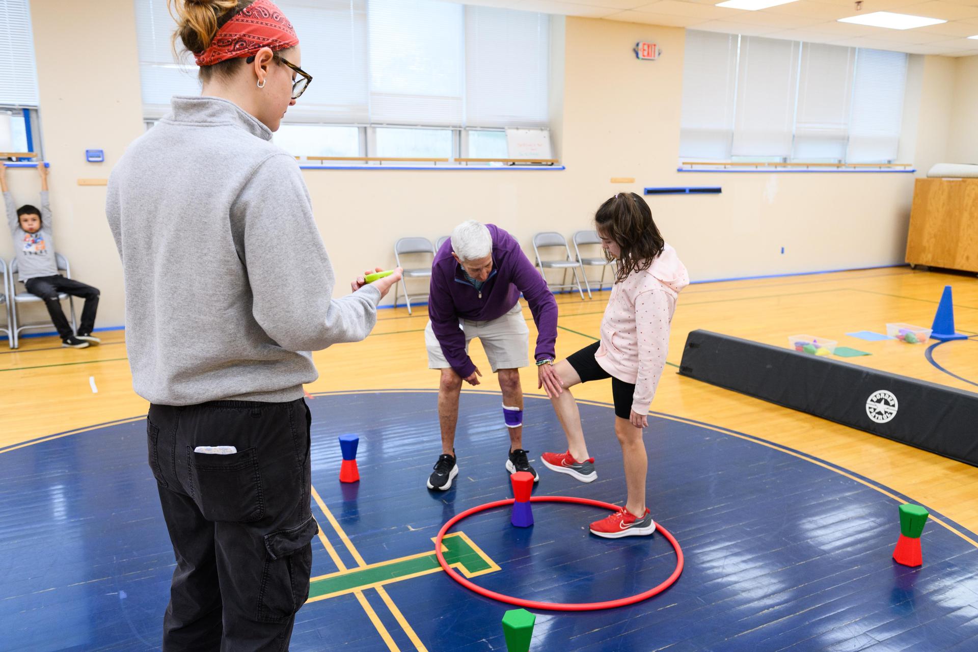 Teacher helping student in gym class.