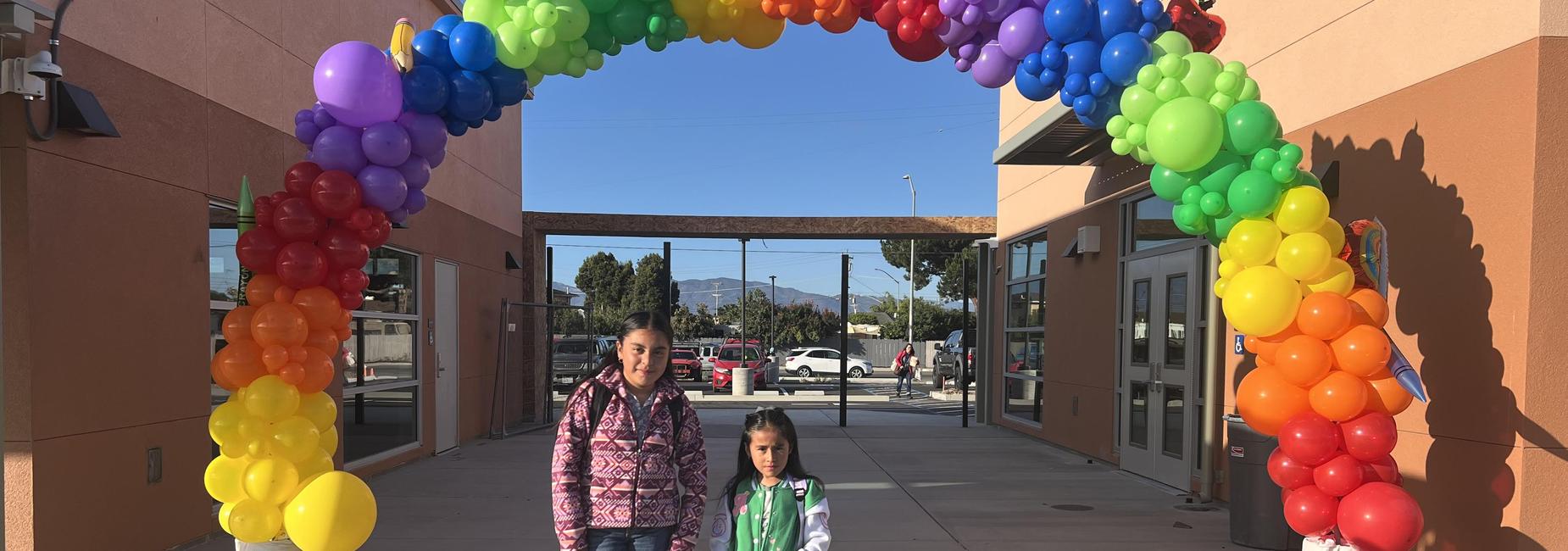 Two students under the rainbow arch.