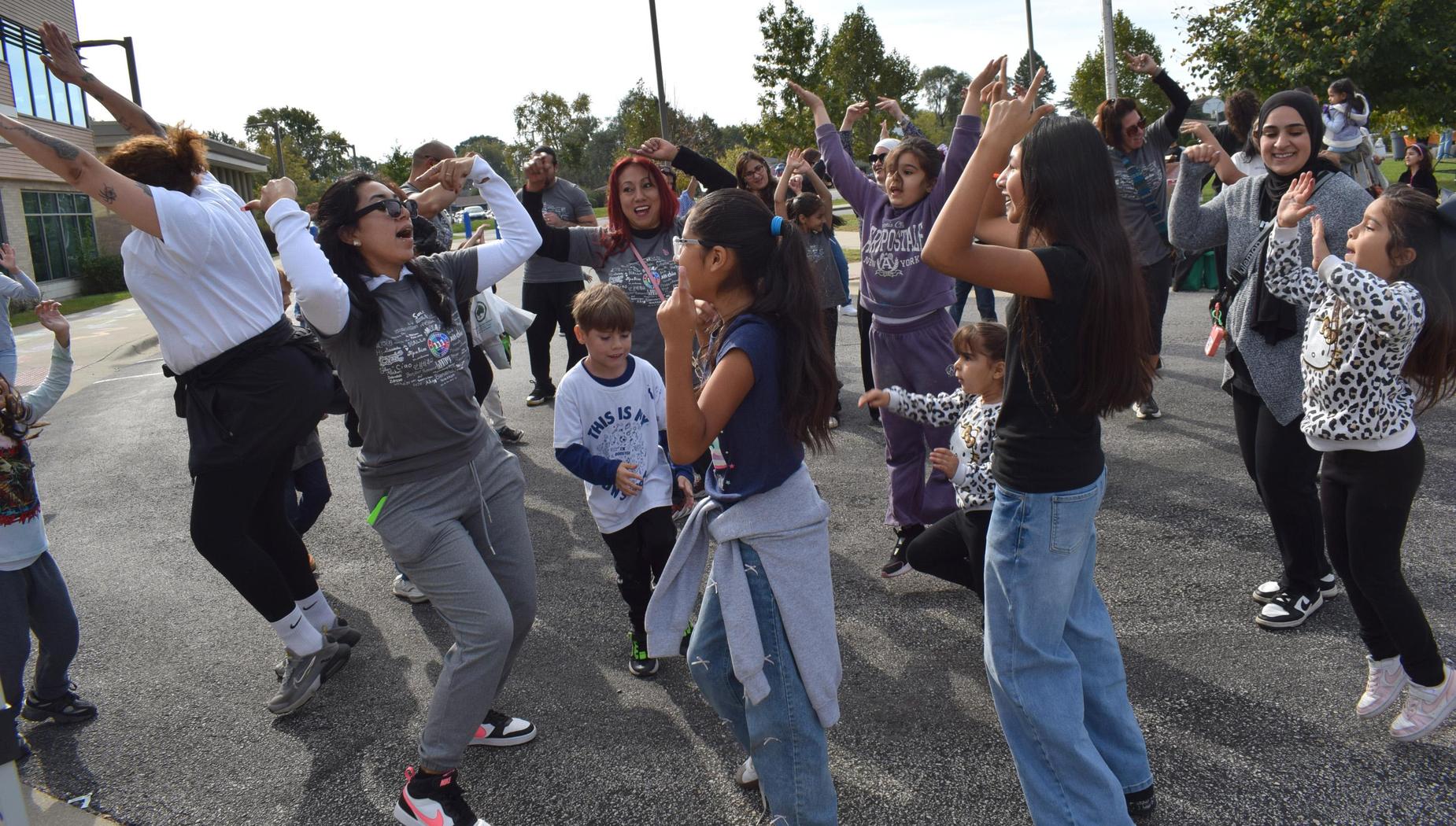 A lively group of people dancing and celebrating outdoors.