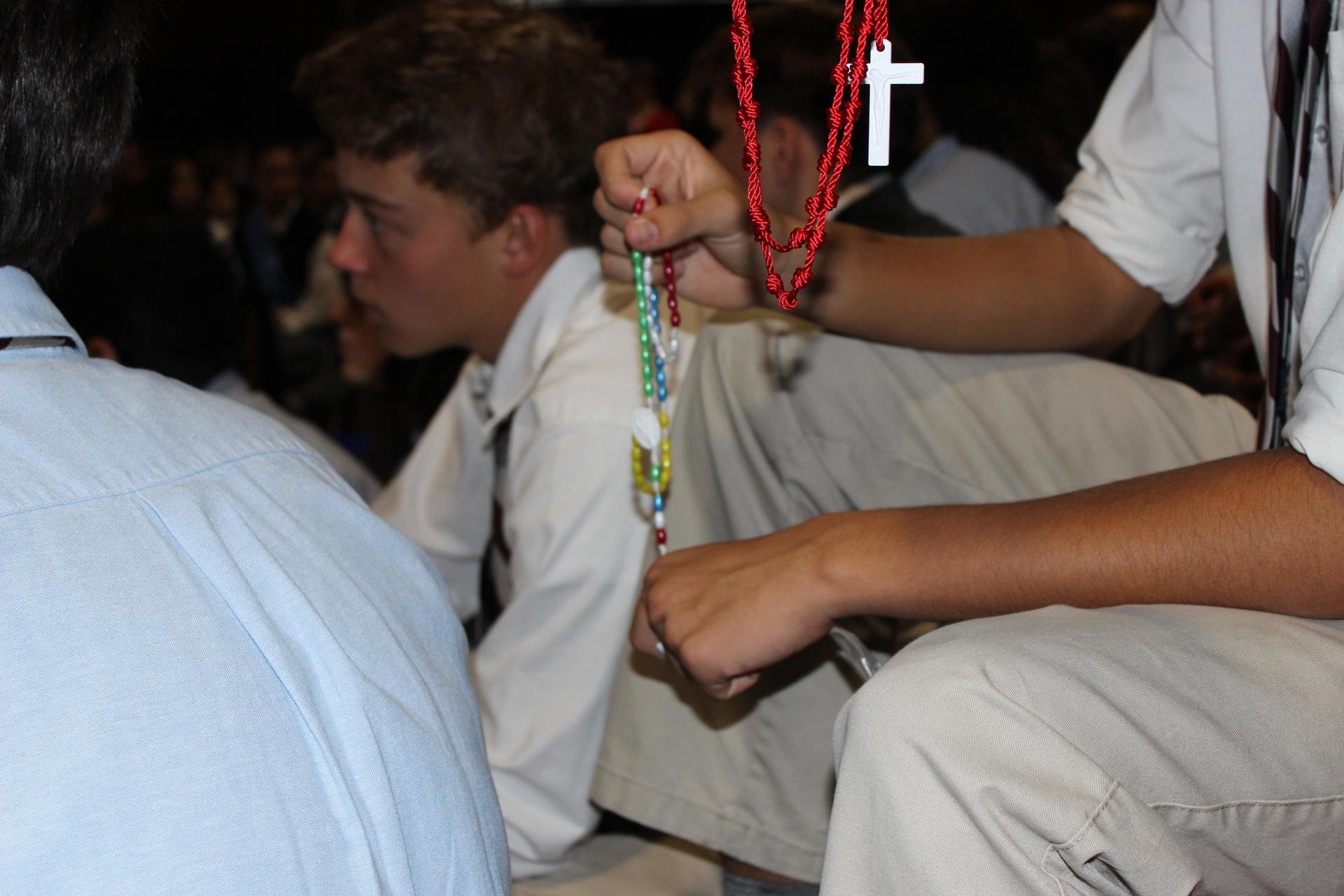 student holding rosary