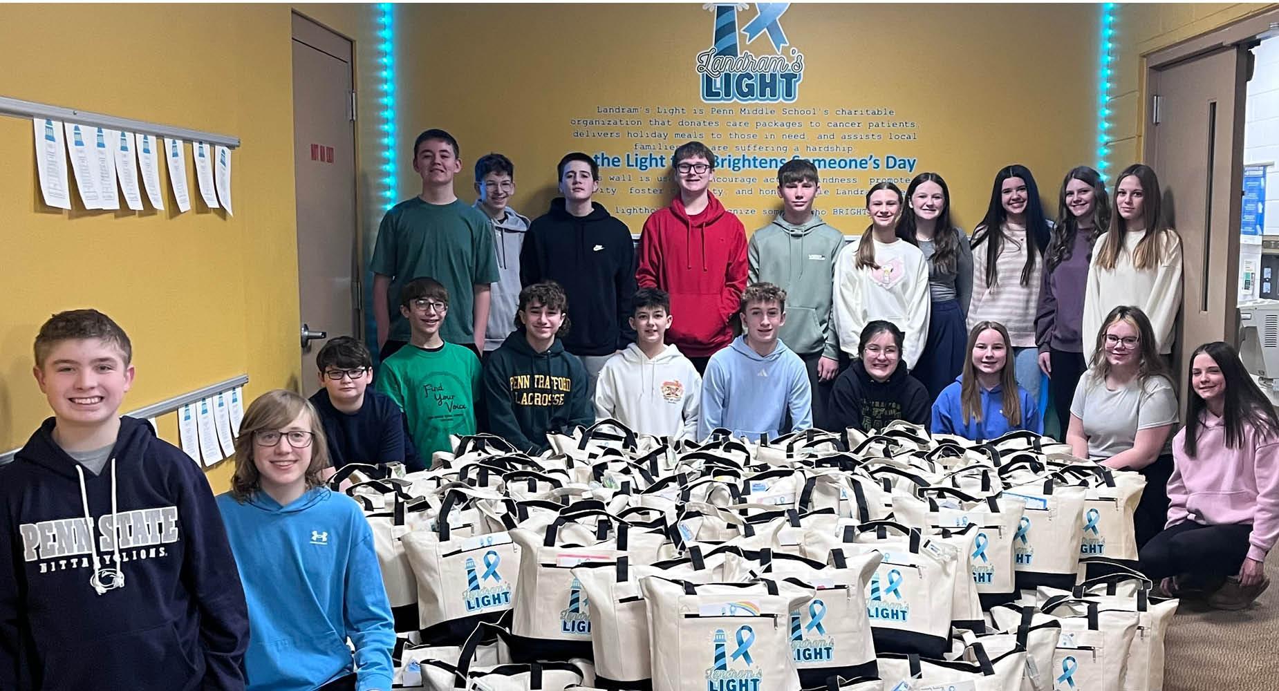 Penn Middle students pose with the 125 totes they packed for cancer patients in support of Landram's Light foundation