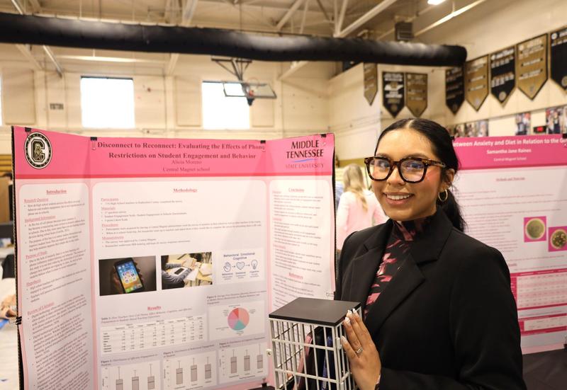 Student standing by their senior project