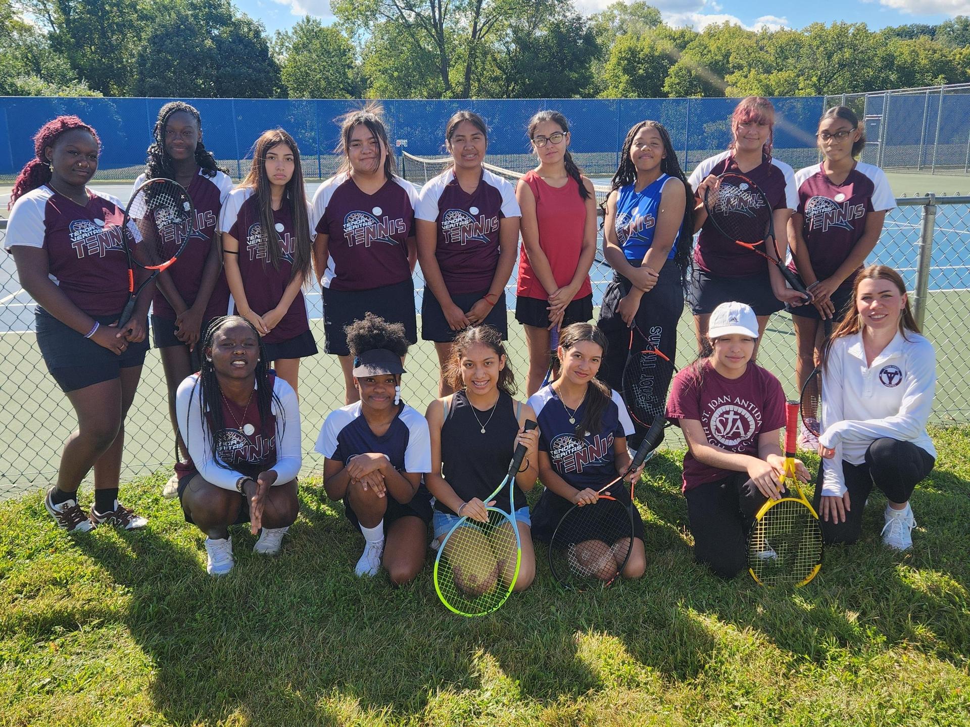 The Tenor Veritas girls tennis team smiling as a group and wearing their uniforms