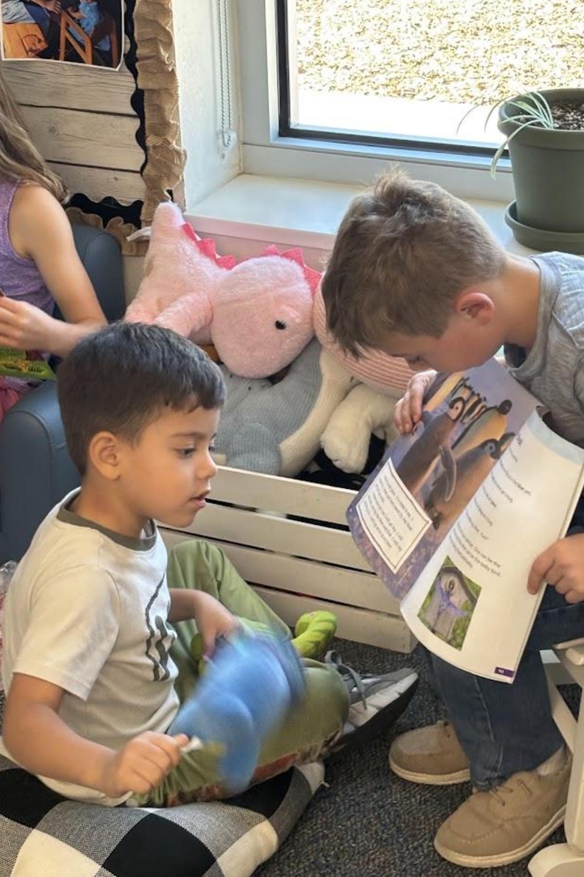 Second grade student reading to preschool student