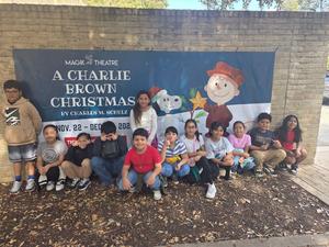 STudents standing in front of wall with sign for Charlie Brown play