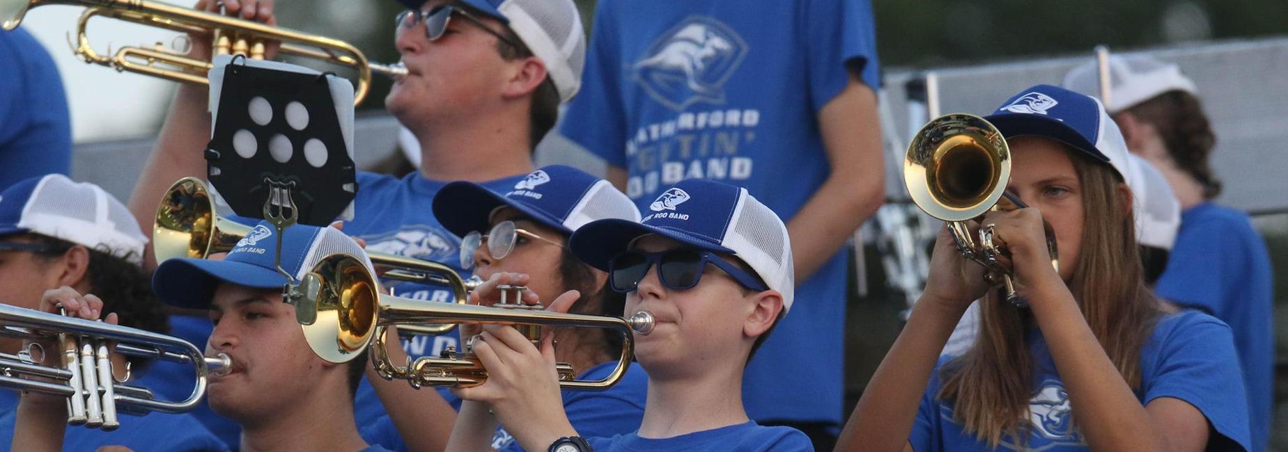 Band students playing instruments at football game