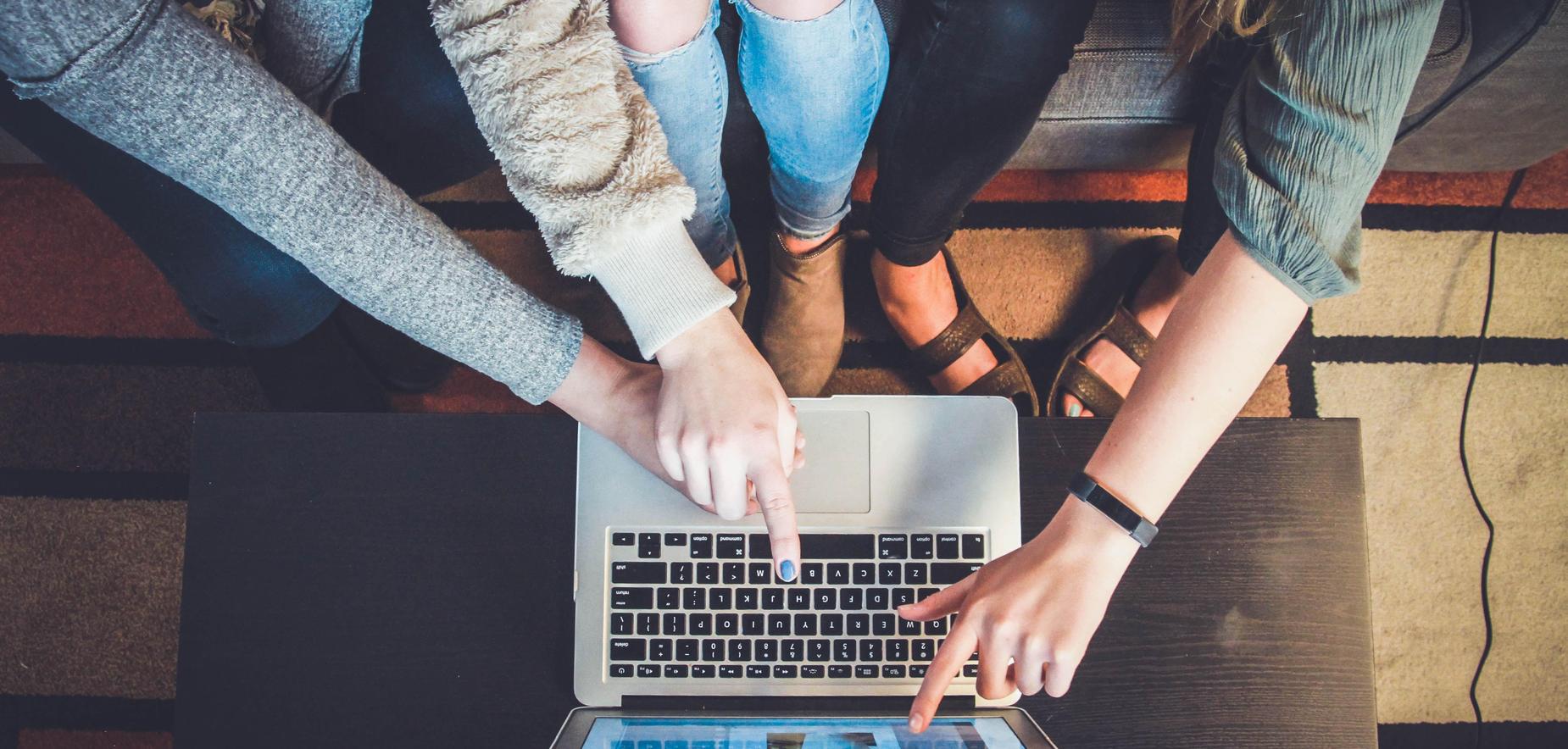 Three students working on laptop together