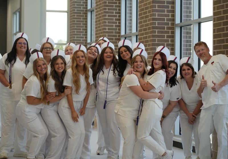 group of practical nursing students in white scrubs