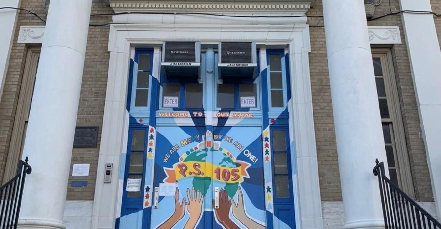Colorful mural on school entrance depicting diverse hands around the globe.