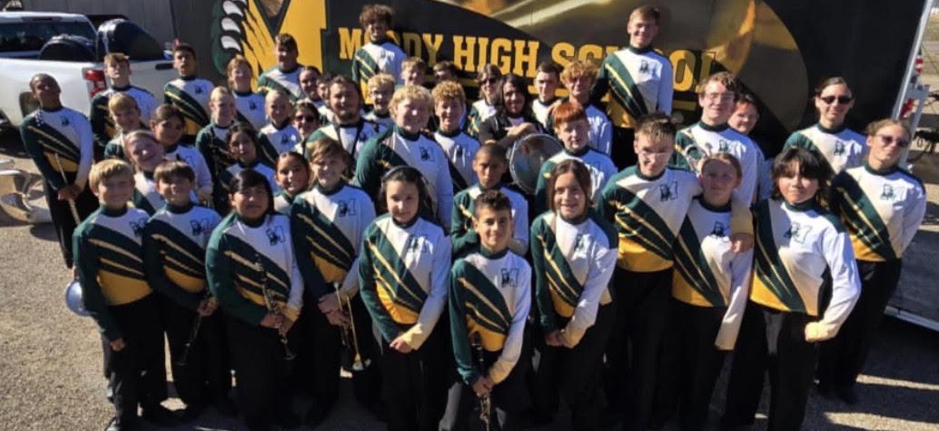 A large group of students in uniforms, posing together for a photo. Bearcat Brigade band.