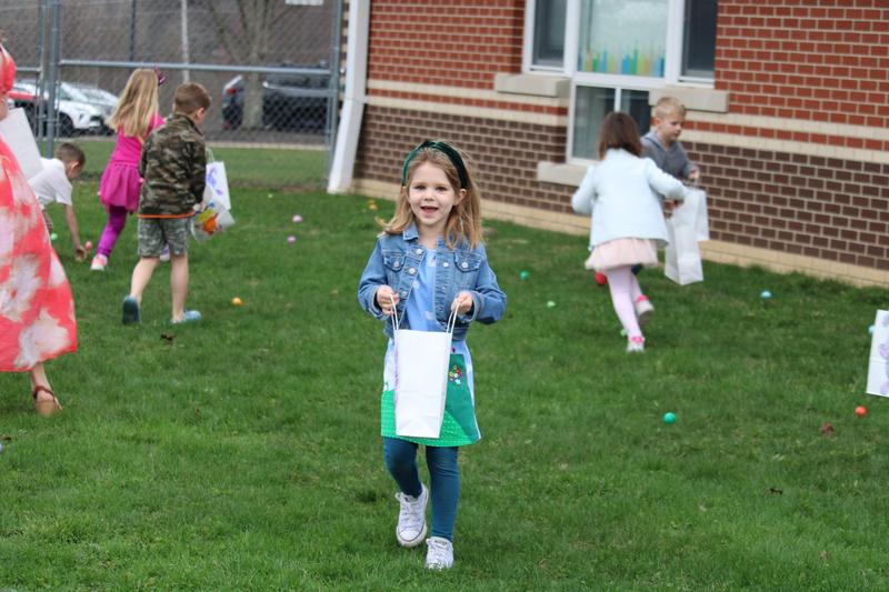 girl holding bag of eggs standing in the grass