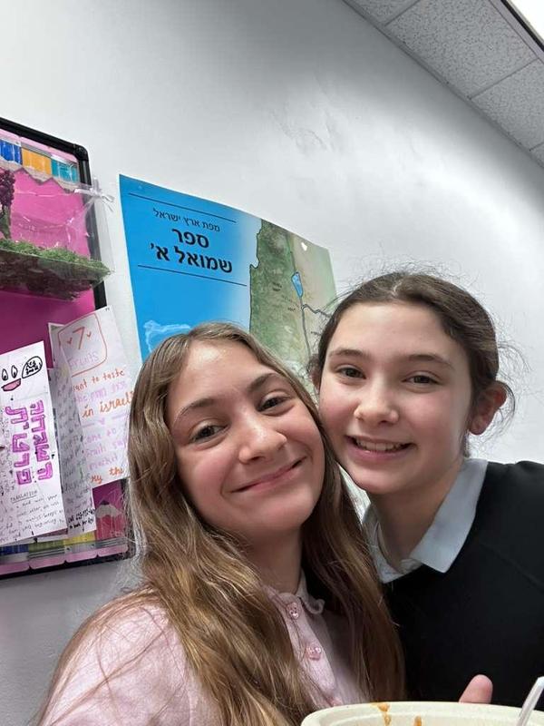 two girls smile together.