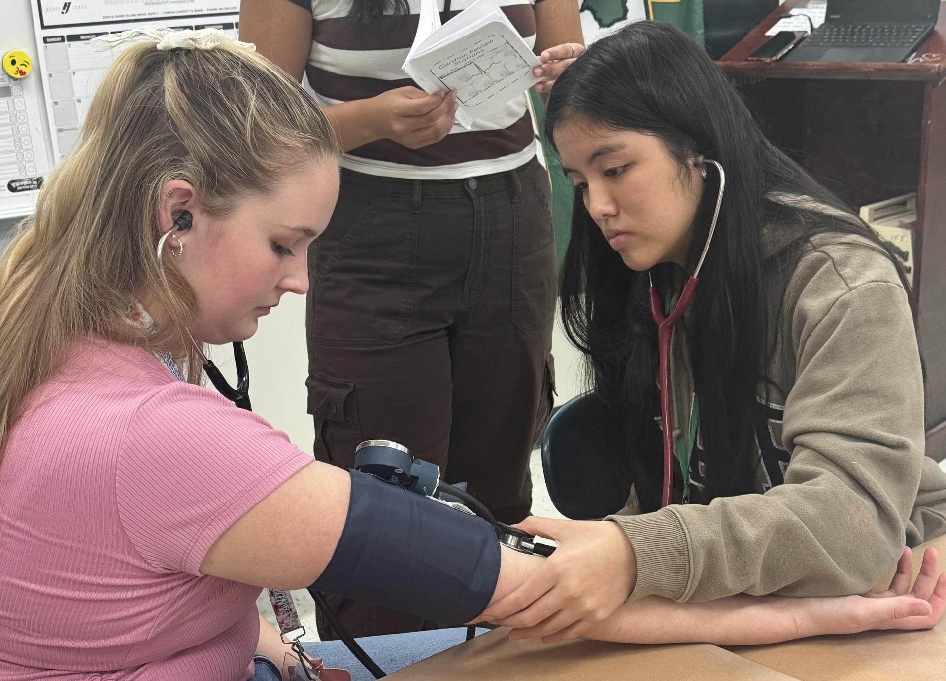 Students practice taking blood pressure readings.