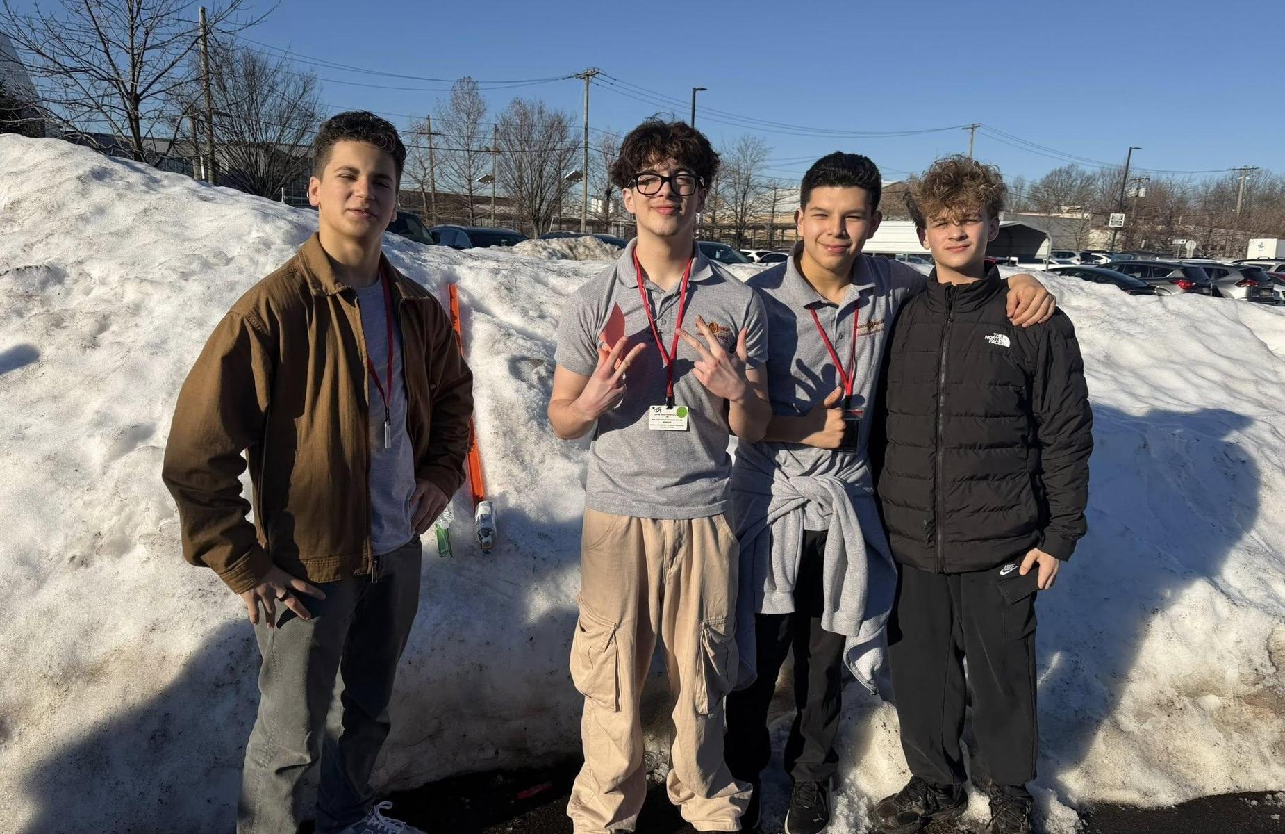 students standing in front of snow pile